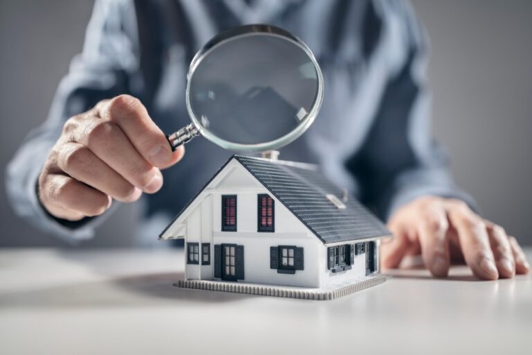 House with a man holding magnifying glass.
